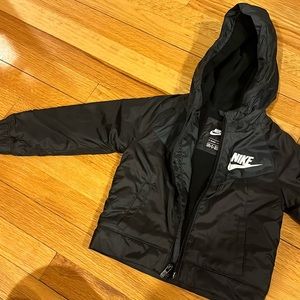 Black Nike fleece jacket with jump suite outside material. Medium weight warmth.